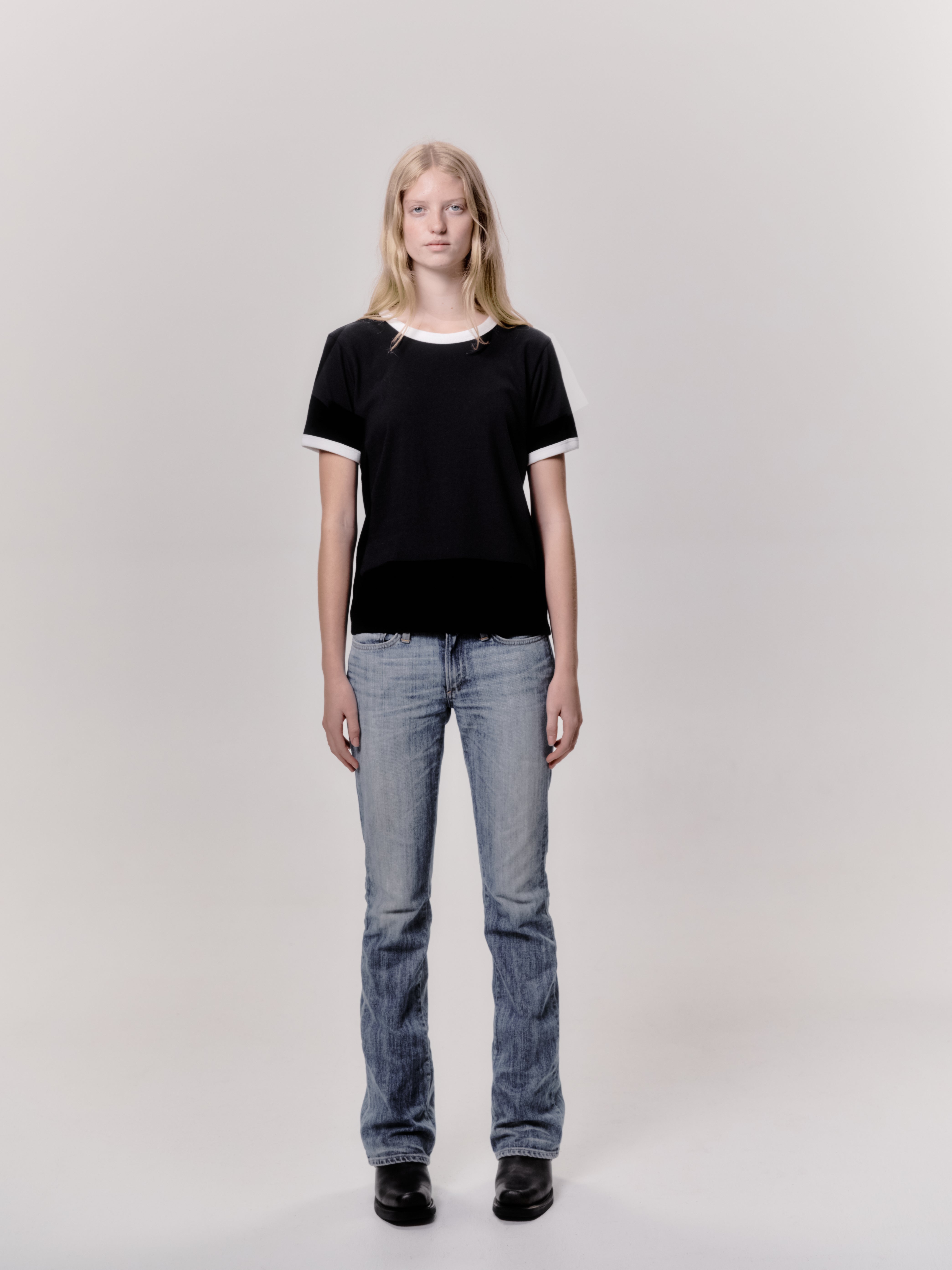 A model wearing the star ringer tshirt in black with white contrast in a white background. 100% made from organic grown cotton. 