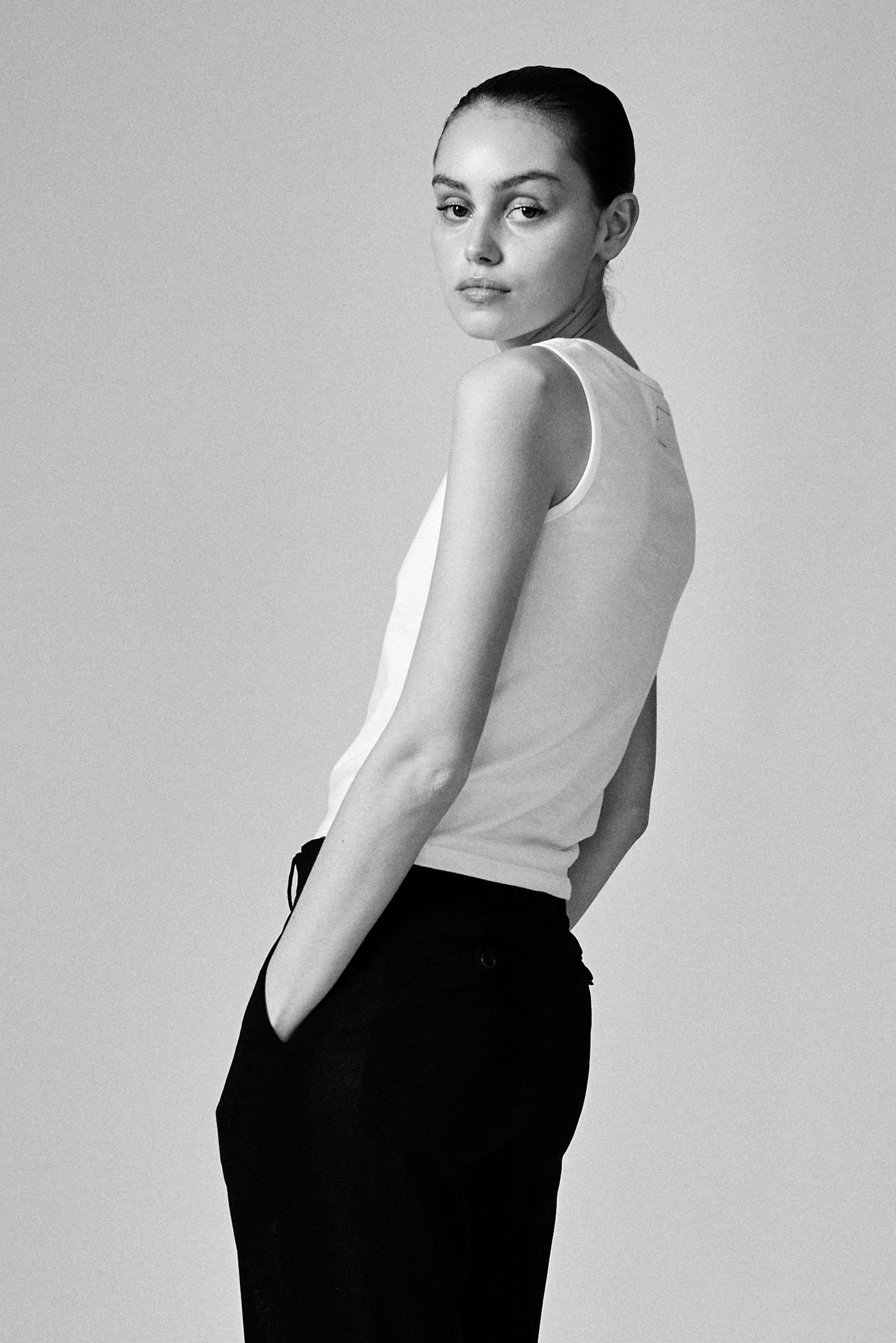 A model wearing the white 03 tank in a white background. 100% made from organic grown cotton.