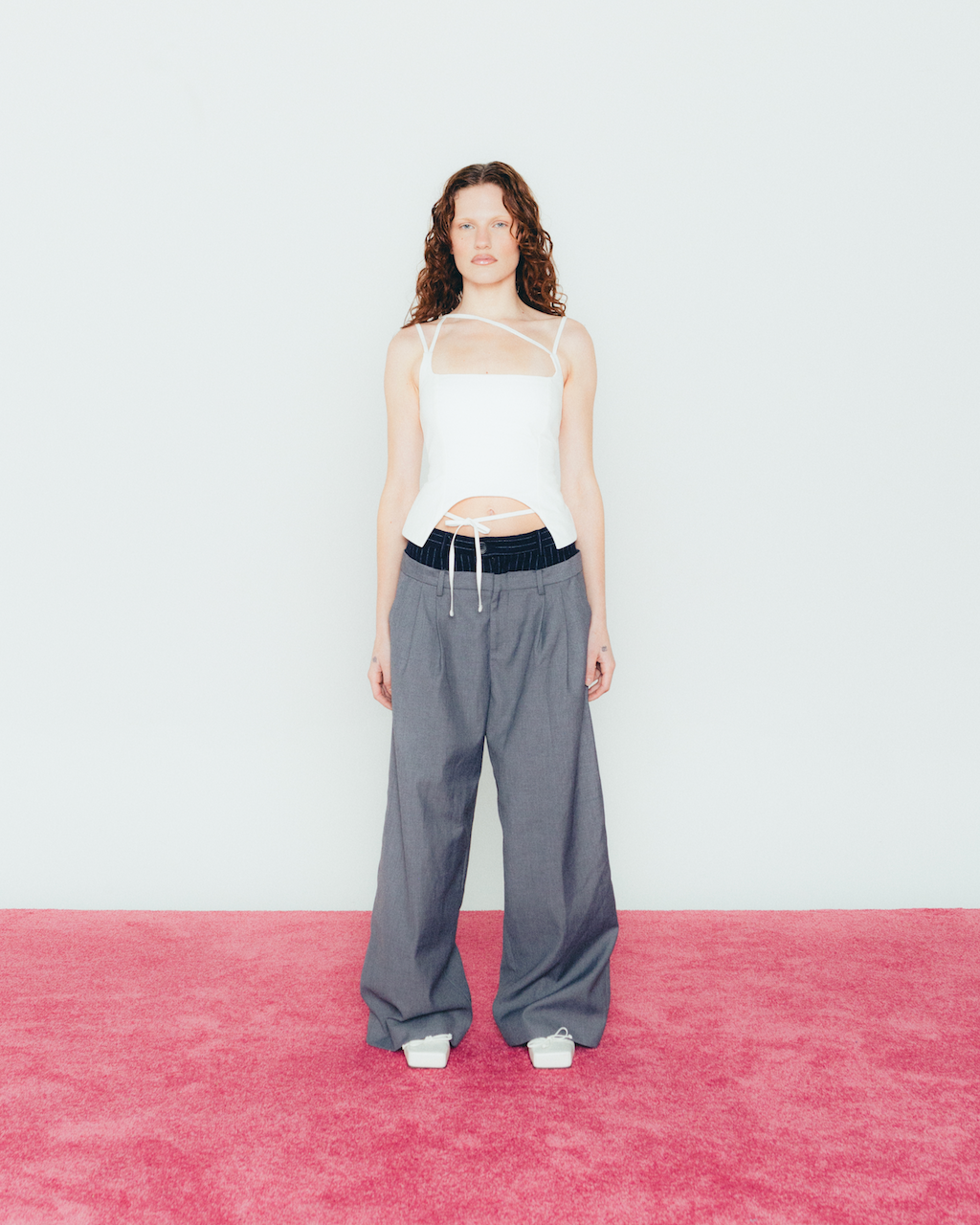 A model wearing the white u top in a white background. Heavyweight 100% Organic Cotton.