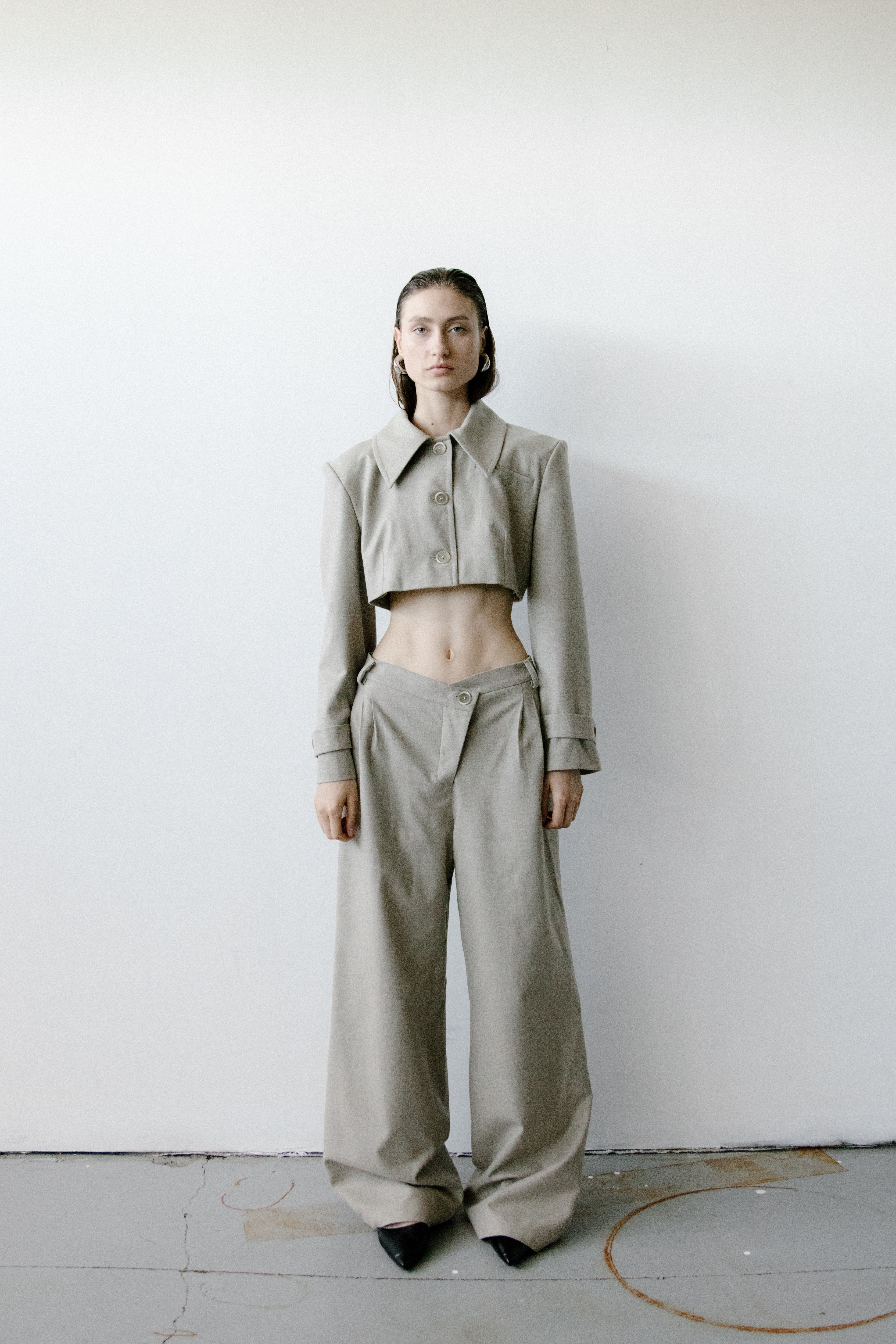 A model wearing the triangle taupe trouser in a white background. 100% made from mulesing-free merino wool.