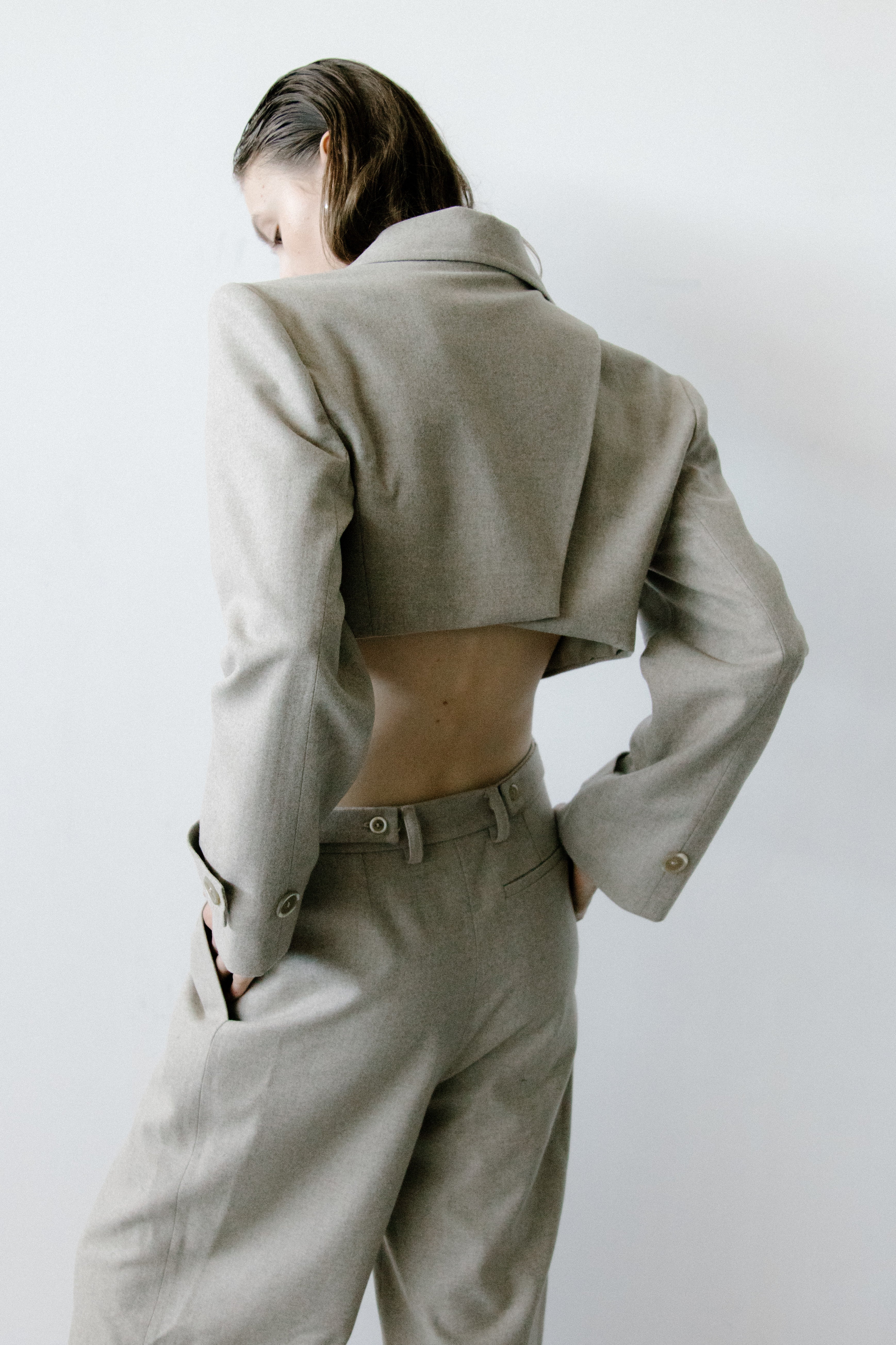 A model wearing the triangle taupe jacket in a white background. 100% made from mulesing-free merino wool.
