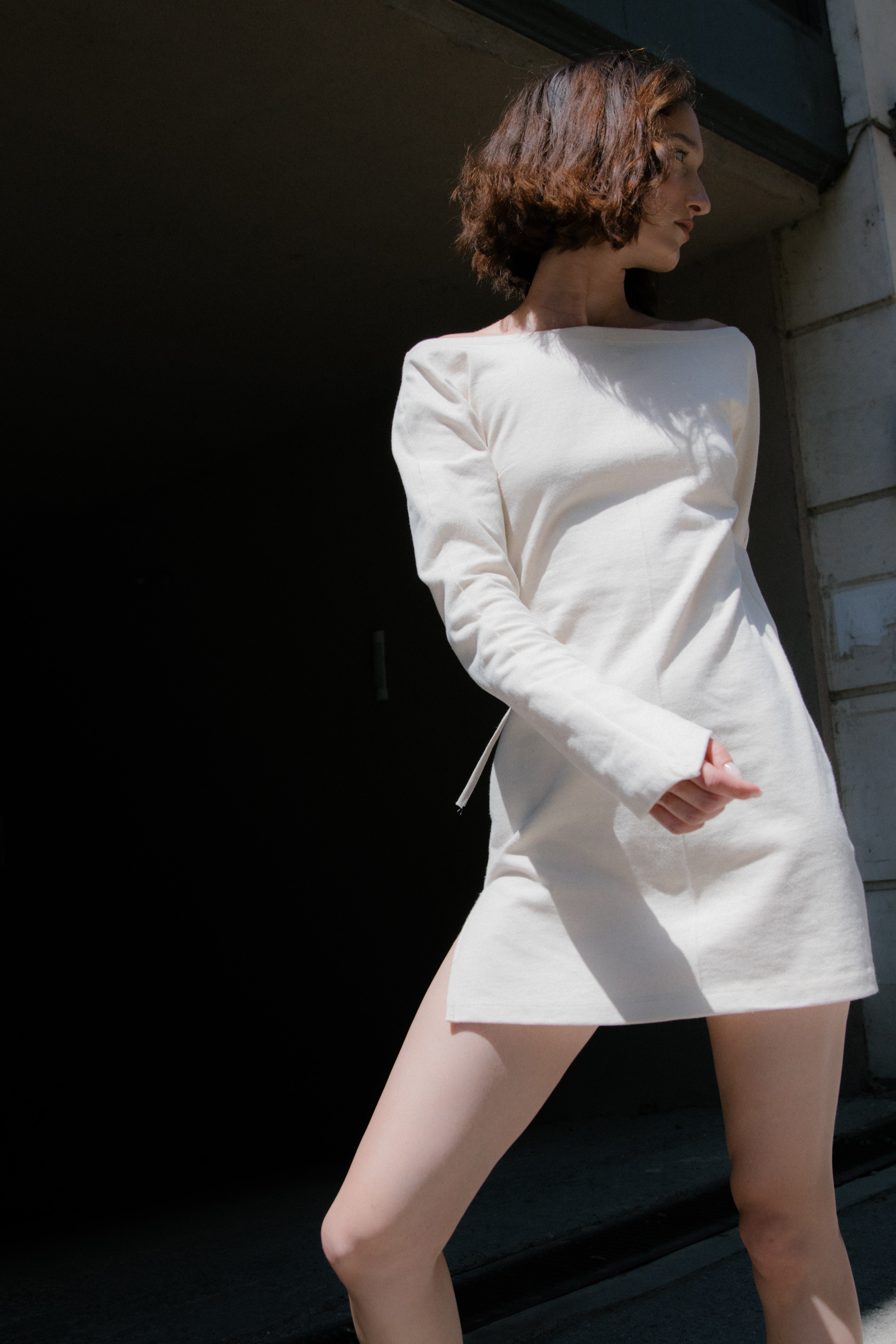 A model wearing the triangle mini dress in an aesthetically background. 100% made from organic cotton. 