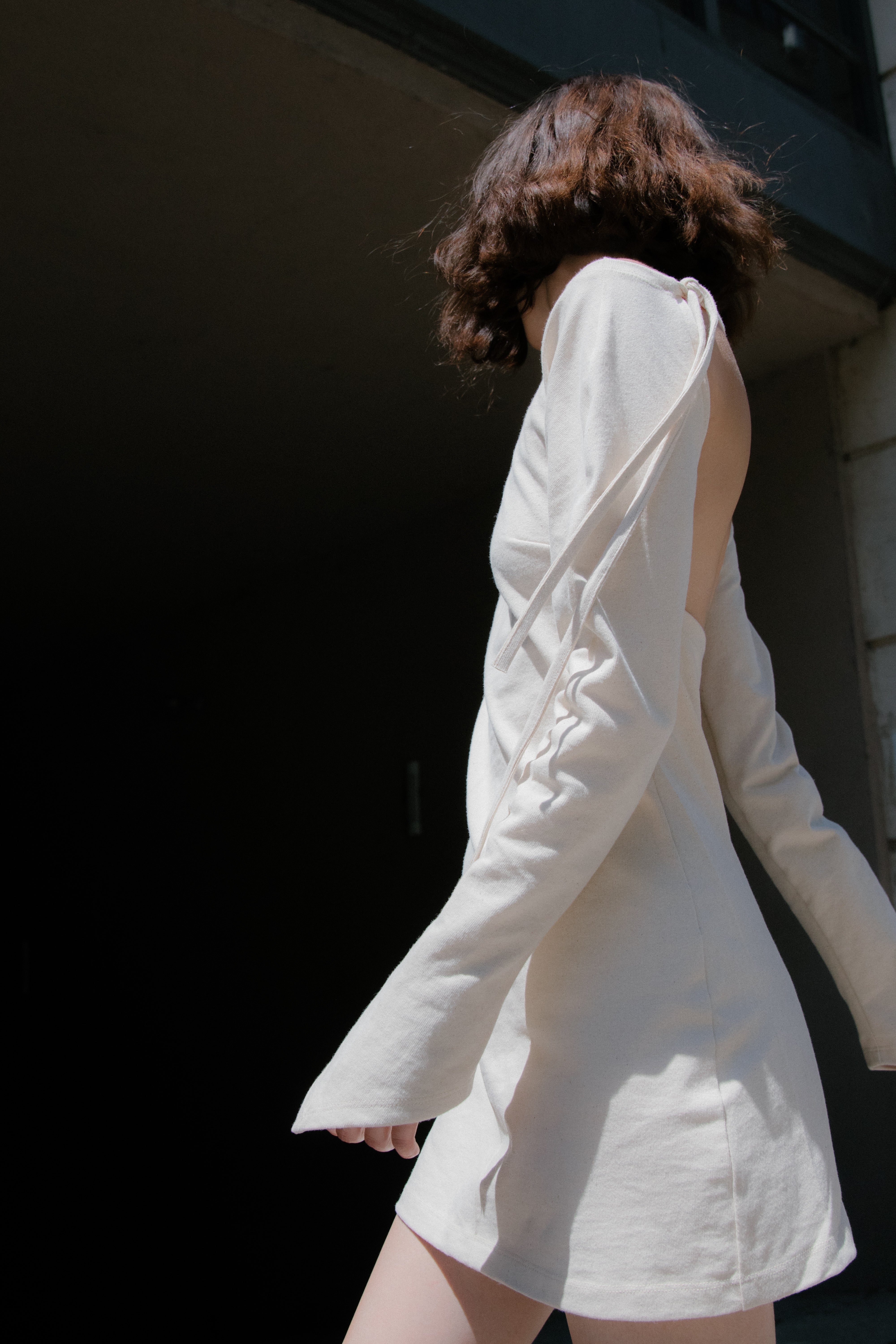 A model wearing the triangle mini dress in an aesthetically background. 100% made from organic cotton. 