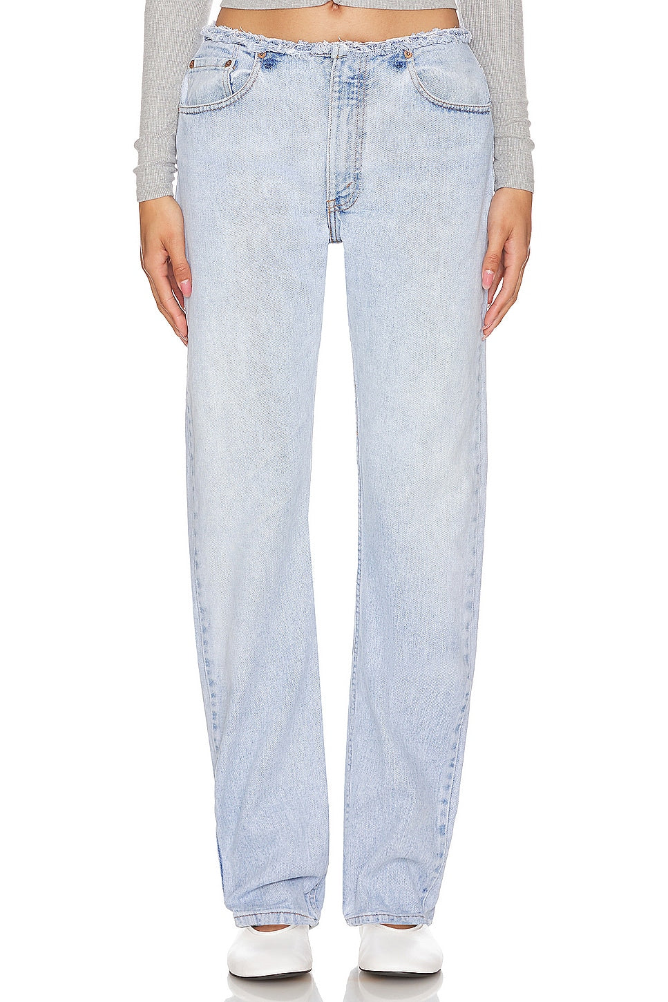 Model wearing an undone mini rise customs in a white background. 100% made from repurposed Levi’s. 