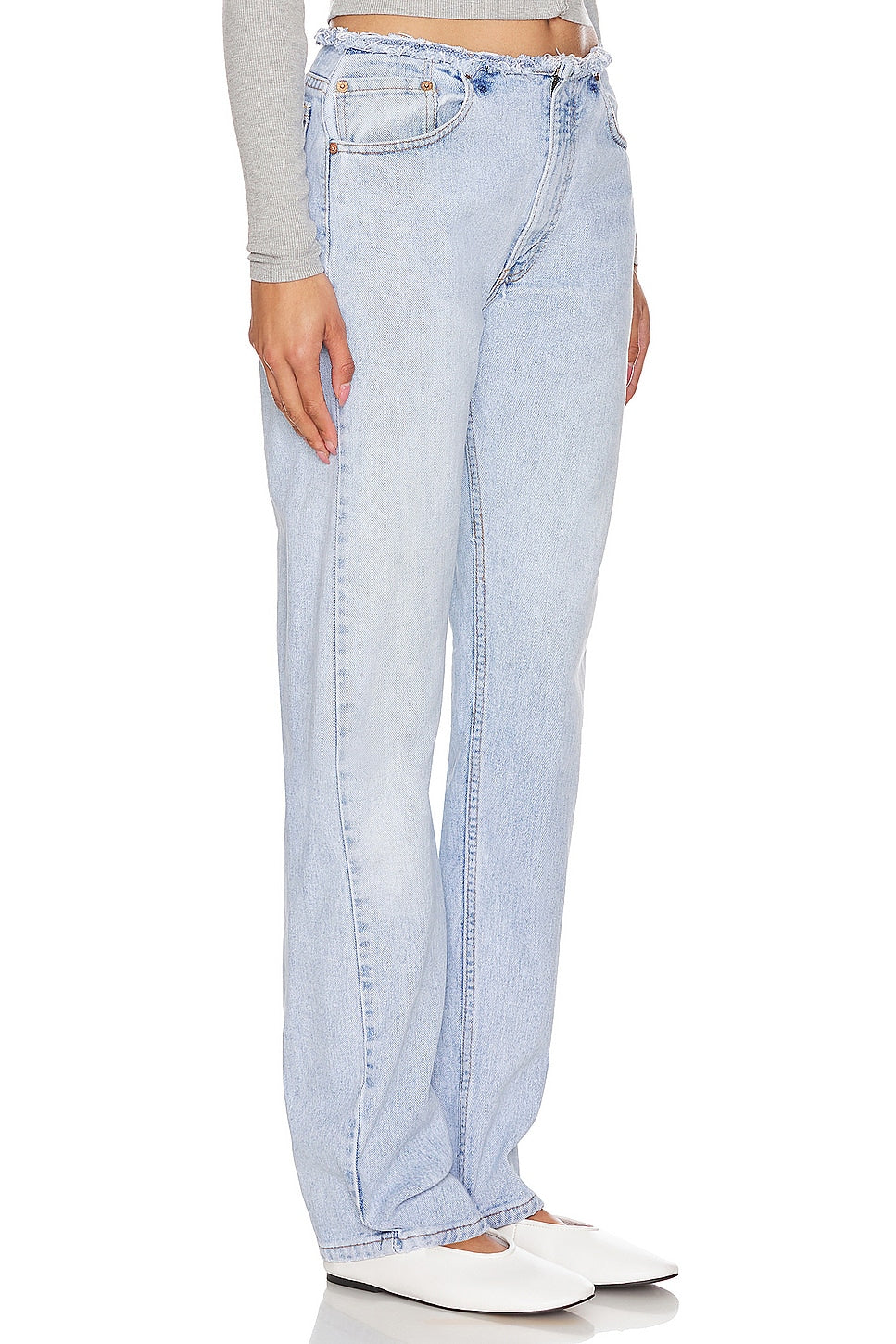 Model wearing an undone mini rise customs in a white background. 100% made from repurposed Levi’s. 