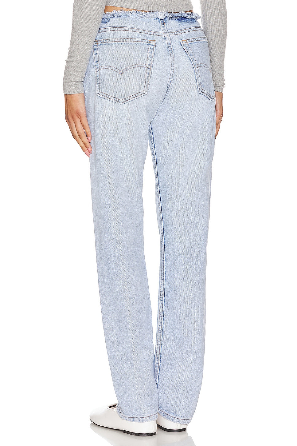 Model wearing an undone mini rise customs in a white background. 100% made from repurposed Levi’s. 