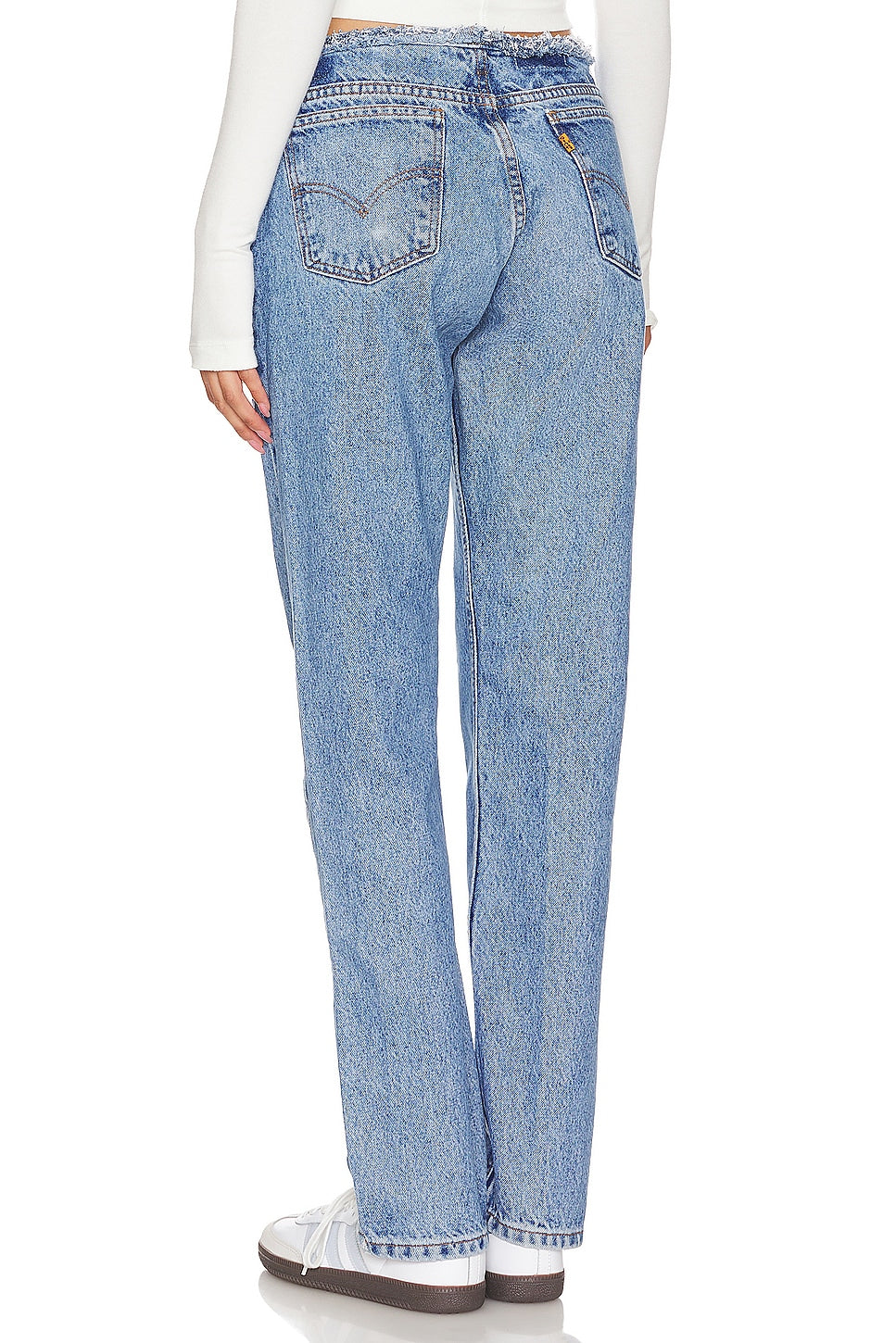 Model wearing an undone mini rise customs in a white background. 100% made from repurposed Levi’s. 