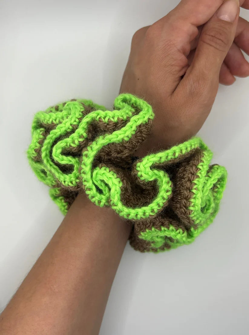 A model wearing the bella scrunchie on her hand in a white background. Handmade in London!