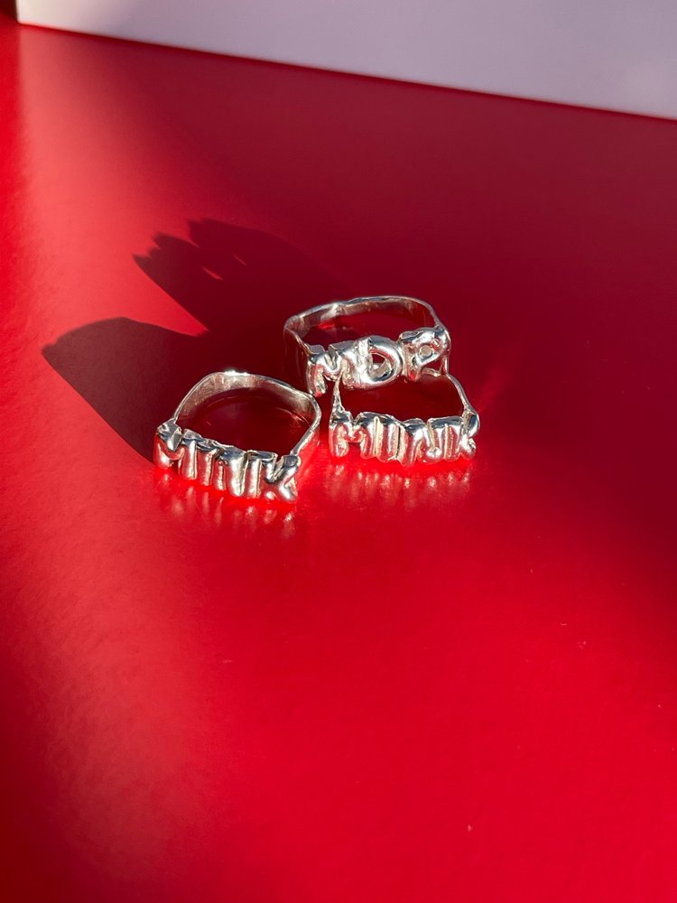 The custom letter ring in a white background. Made from 100% recycled metals and lab created gemstones. CLOSE UP