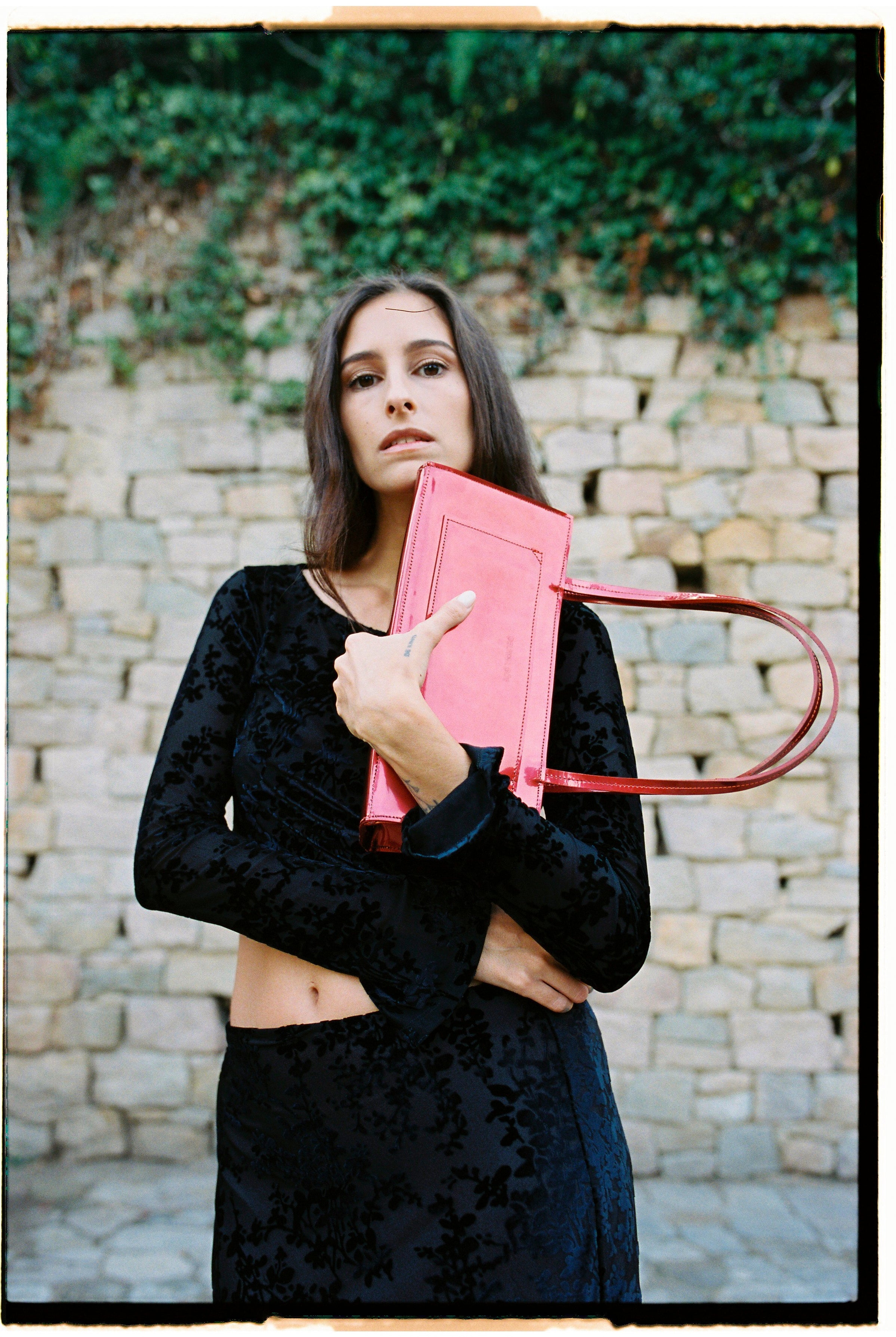 A model holding a hotdog bag in an aesthetically background. 100% made from deadstock leather.