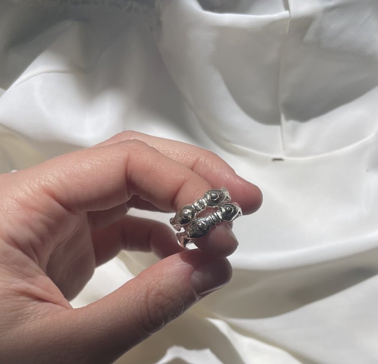 The kissing fish ring in a white background. Made from 100% recycled metals and lab created gemstones. CLOSE UP