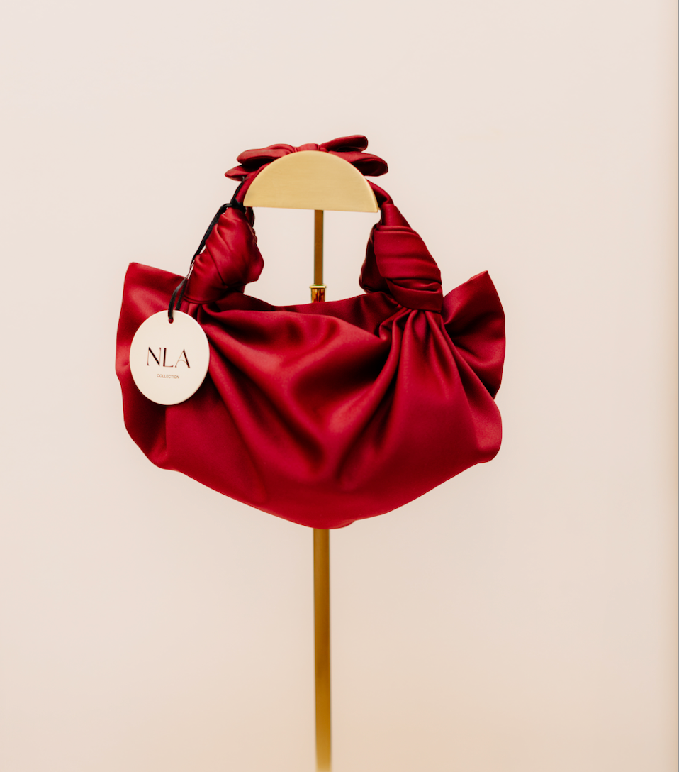The merlot silk knot bag on display in a white background. Deadstock silky satin fabric sourced in Los Angeles.