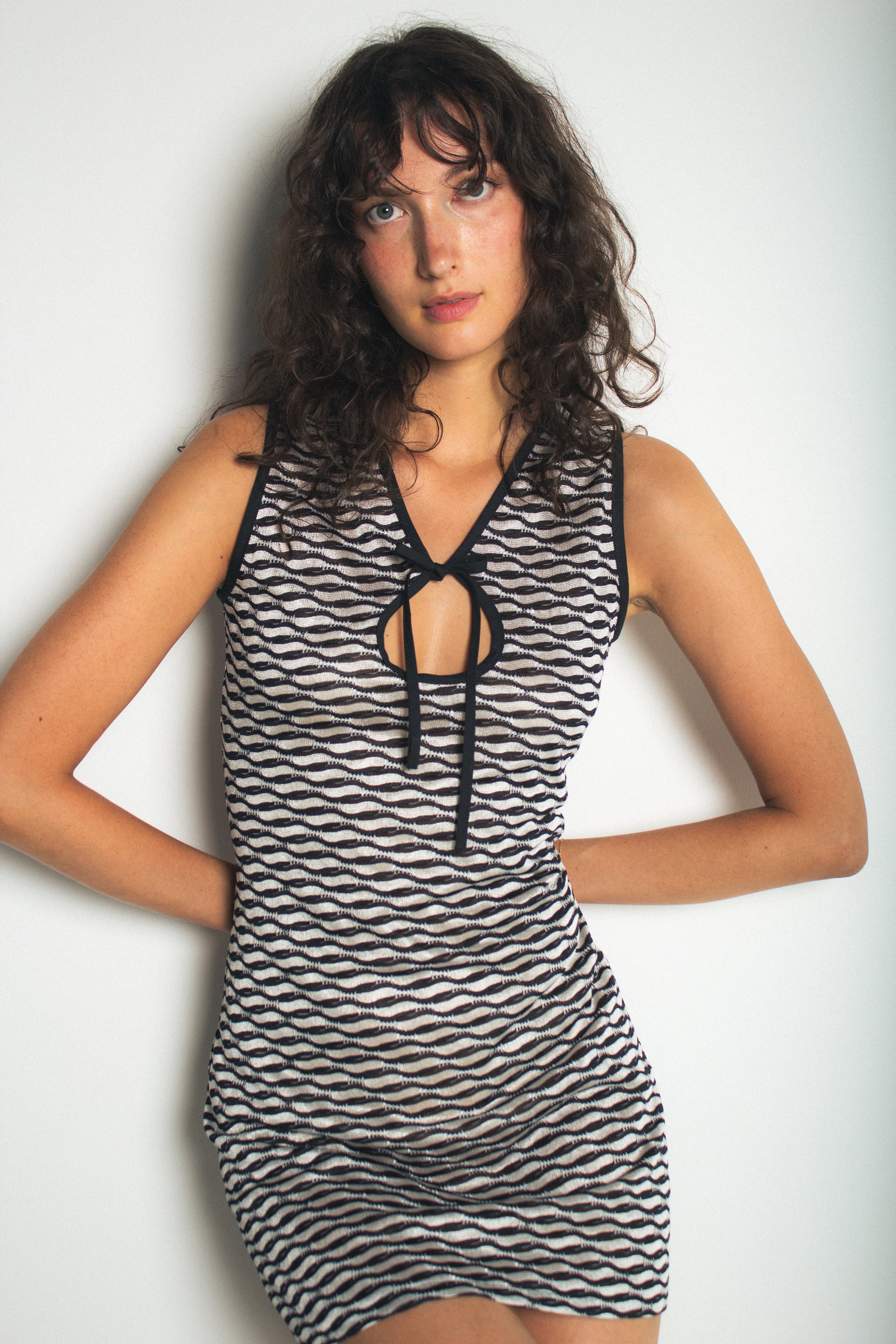 A model wearing the short demie dress in a white background. 100% deadstock Missoni-like, stretch knit blend.