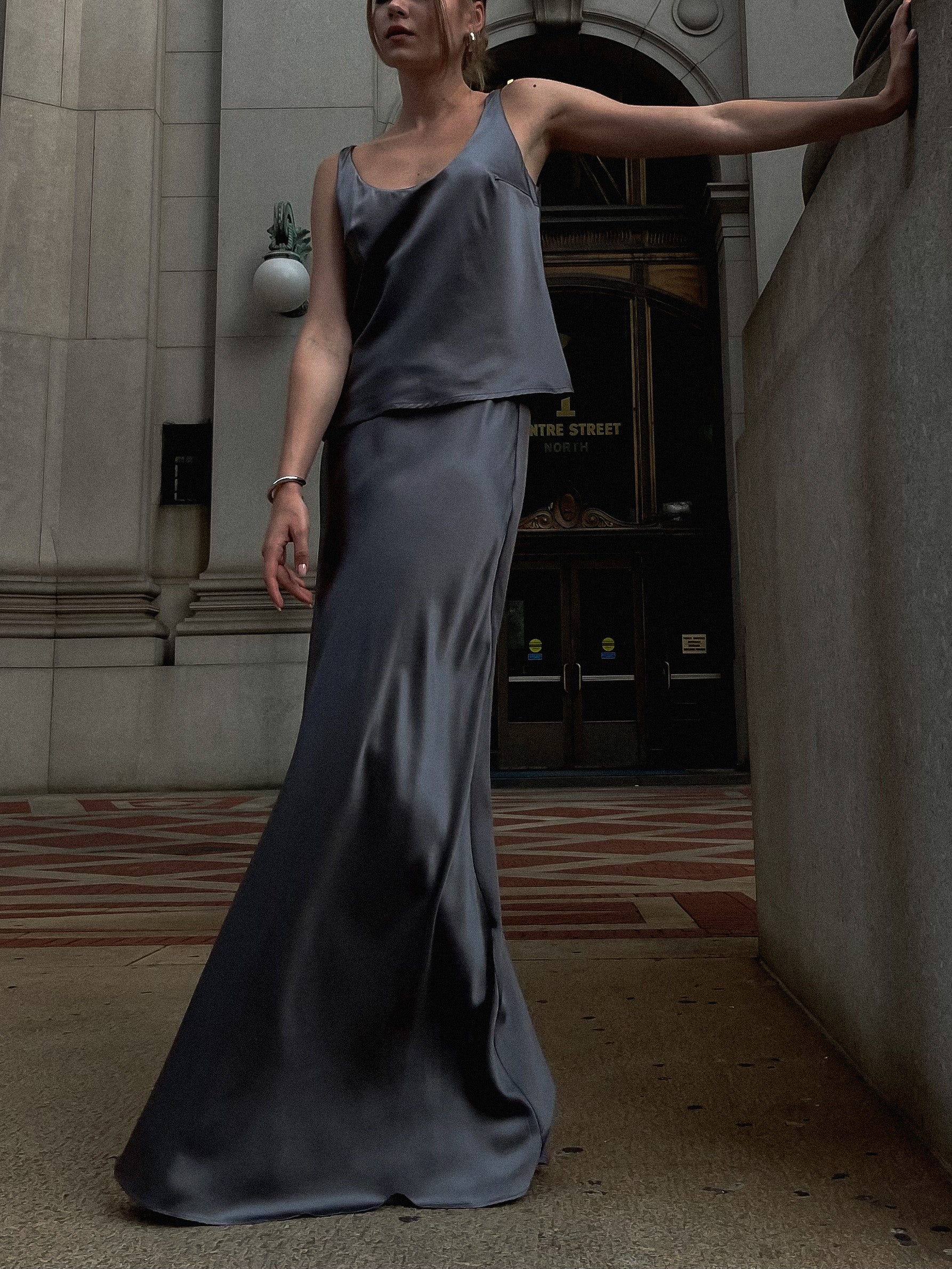 A model wearing the pearl grey siren skirt in an aesthetically background. 100% made from sustainable silk. 